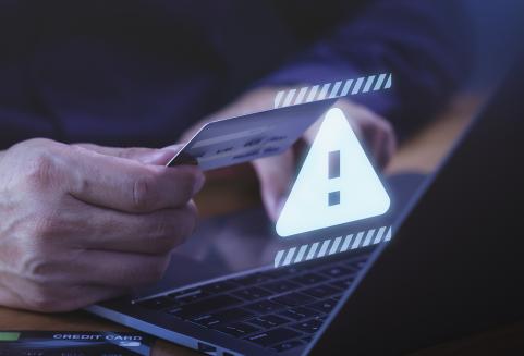 Läppärin ääressä luottokortti kädessä.