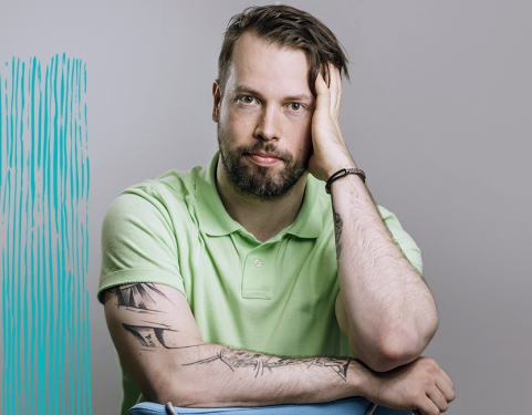 Vakava mies nojaa käteensä ja katsoo kohti.